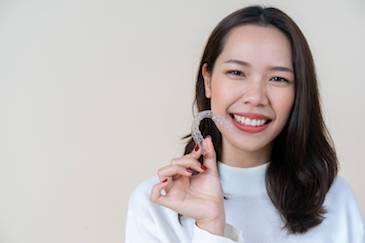 woman holding invisalign