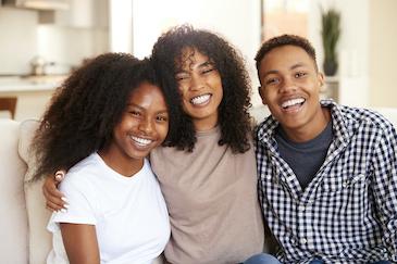 mom, son, and daughter smiling