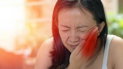 woman holding jaw in pain