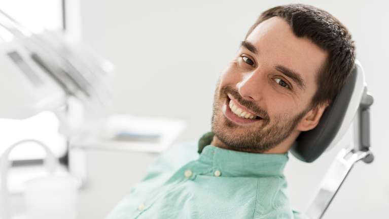 man sitting in dental exam chair | dentist arlington wa