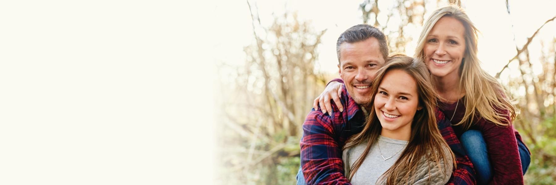 Family of three smiling at Gissberg Twin Lakes in Arlington WA